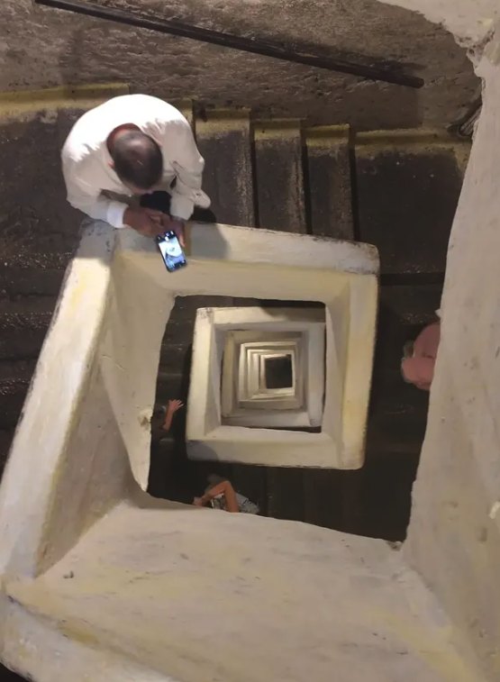 Looking down the square shaft of the Naples Underground staircase, its flights turning back on themselves through the tuff